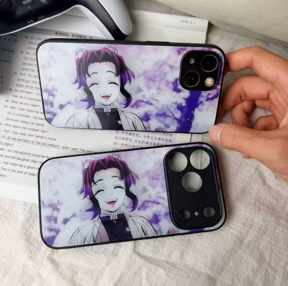 Phone case with anime character design held by a hand on a textured surface