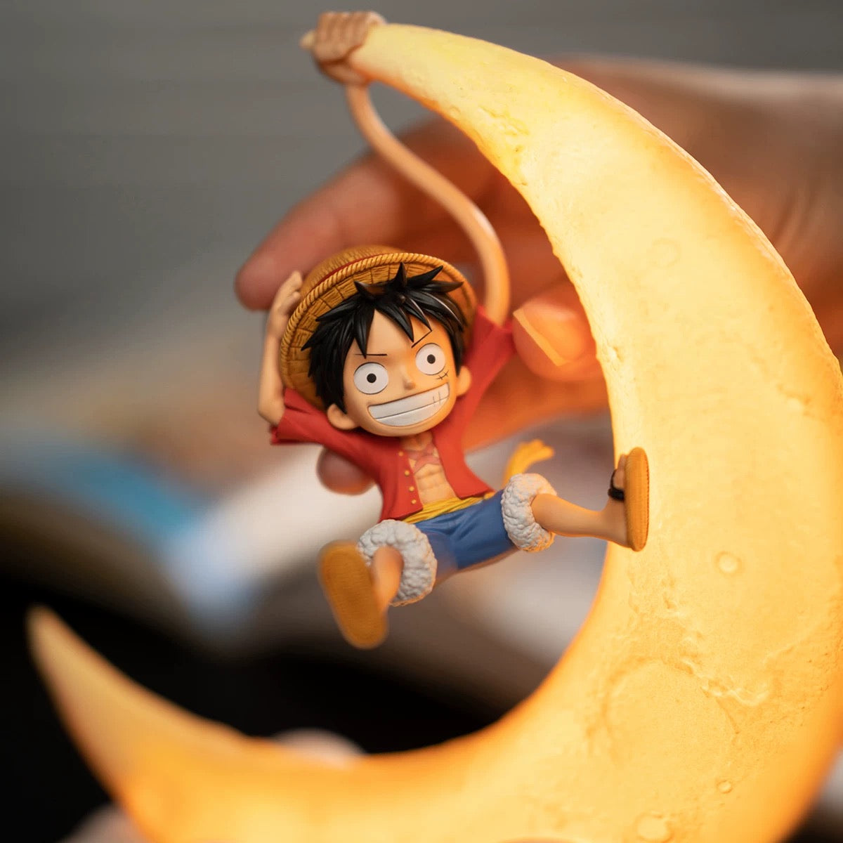 Figurine of a character from a popular anime series sitting on a crescent moon.