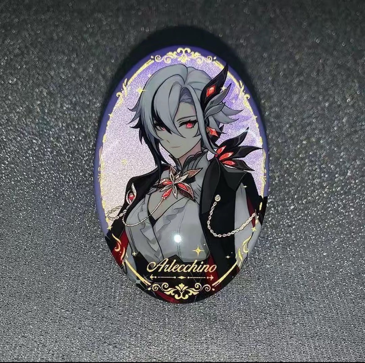 Oval-shaped brooch with an anime-style character design on a dark textured background
