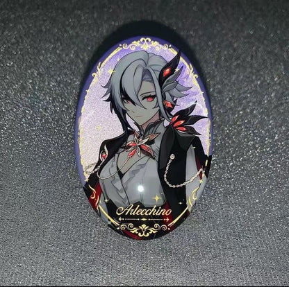 Oval-shaped brooch with an anime-style character design on a dark textured background